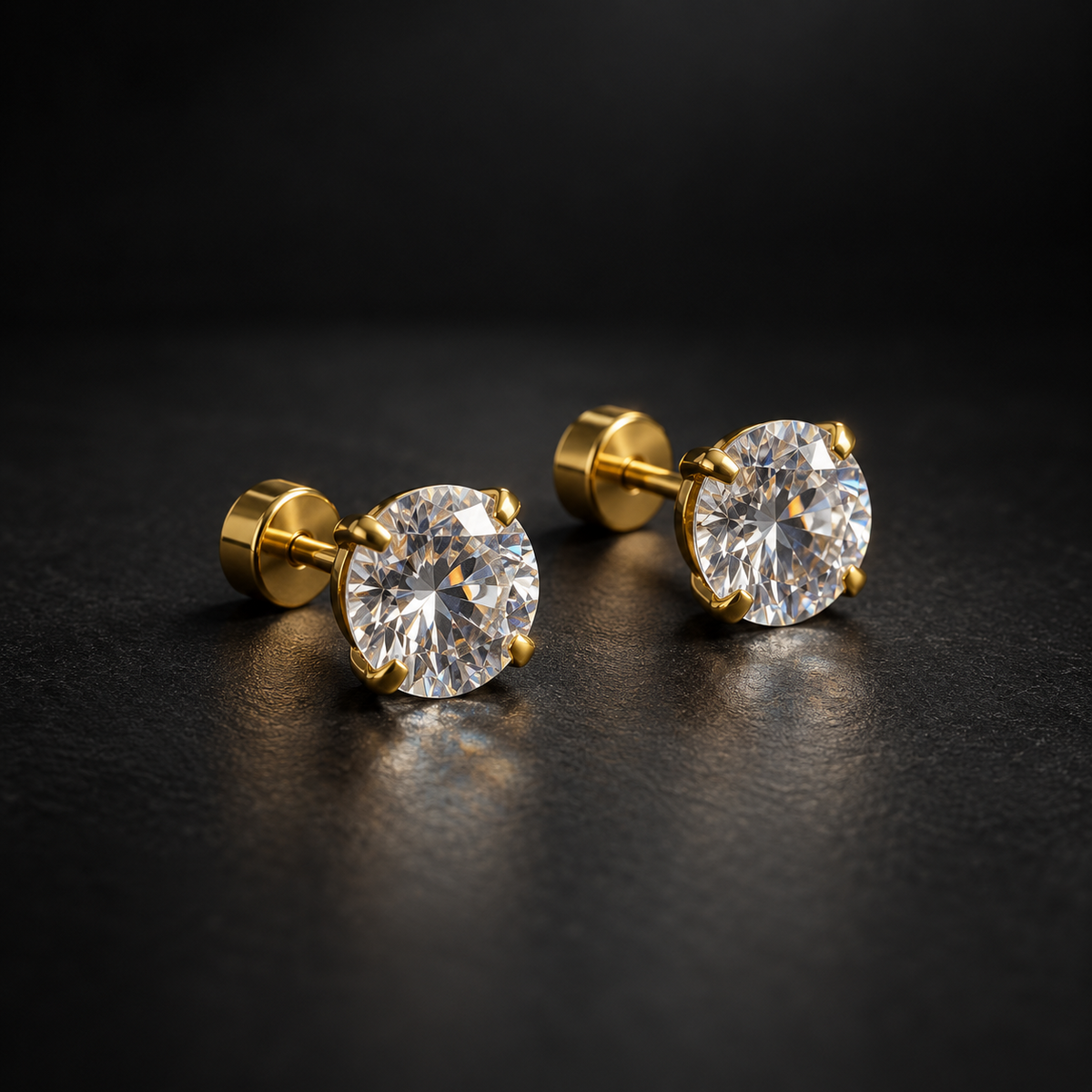 Gold stud earrings angled on black surface