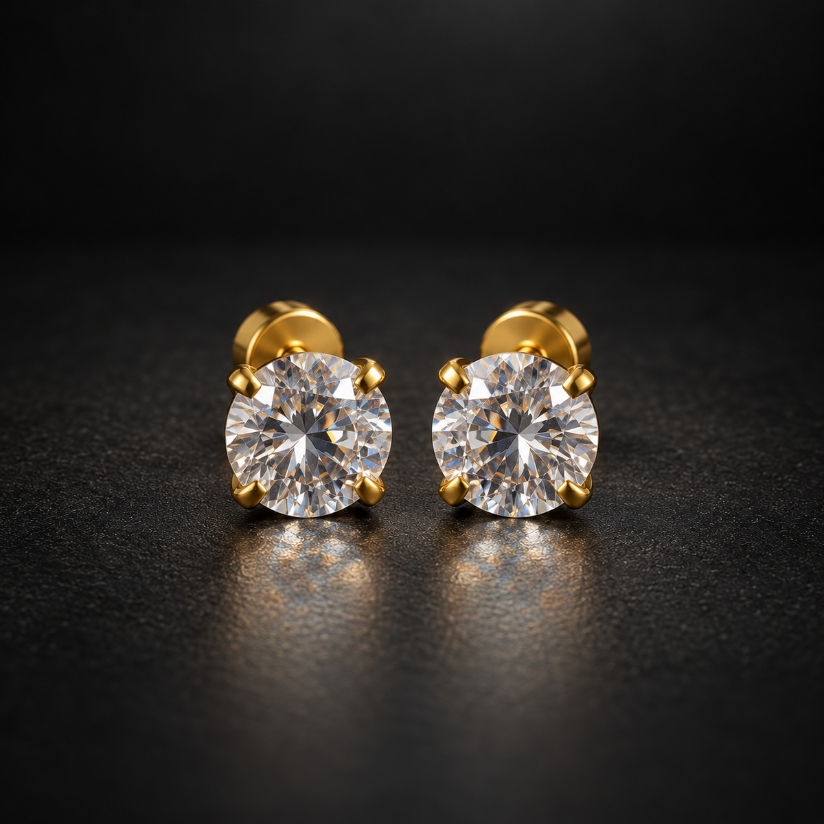 Front view of gold stud earrings on black surface